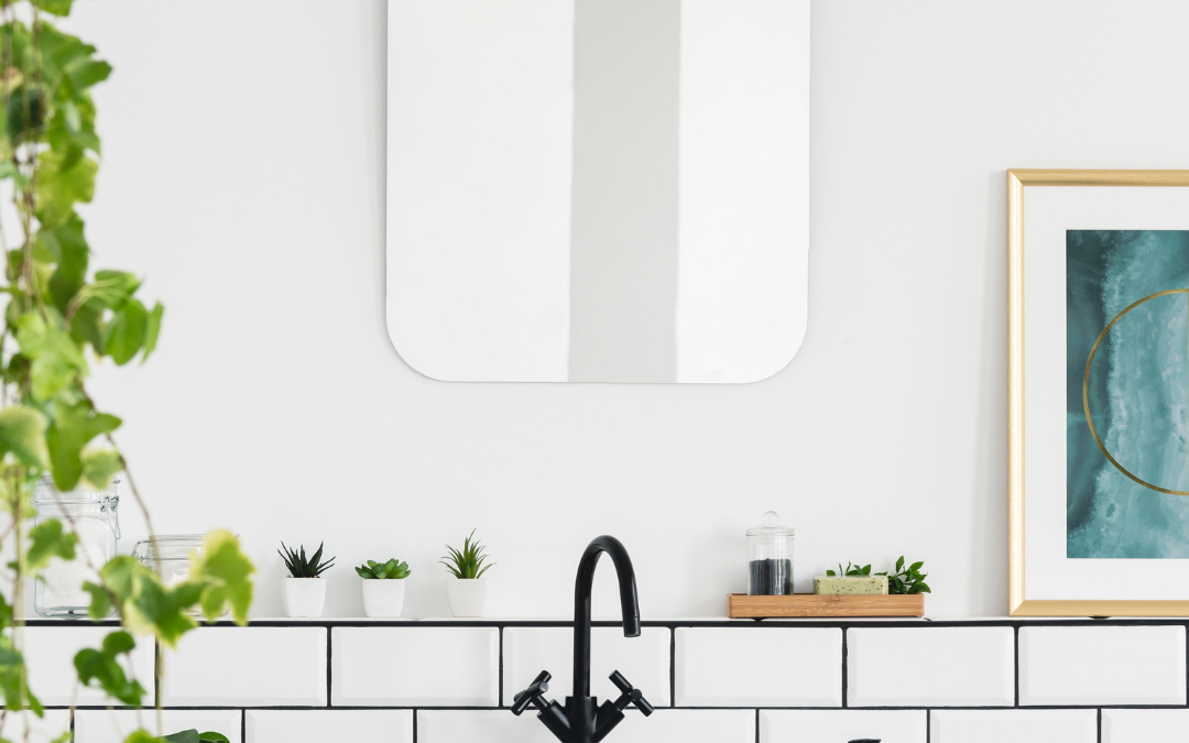 white bathroom with mirror and greenery on the left