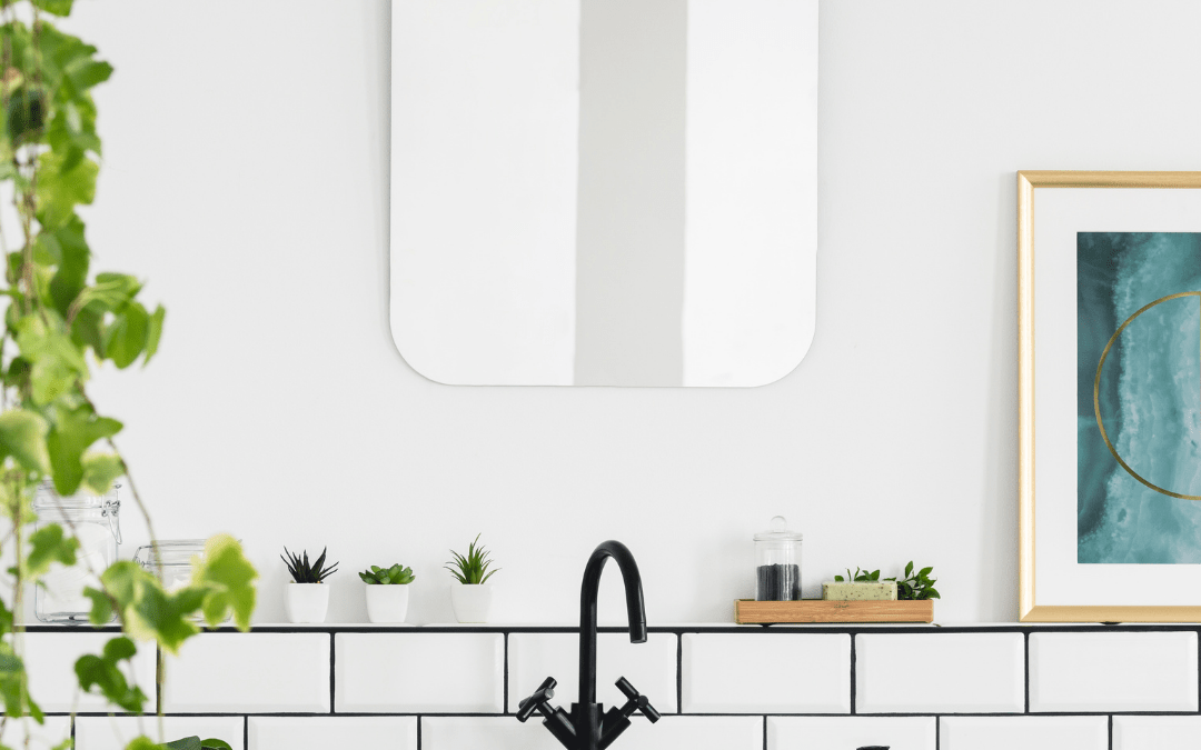 white bathroom with mirror and greenery on the left