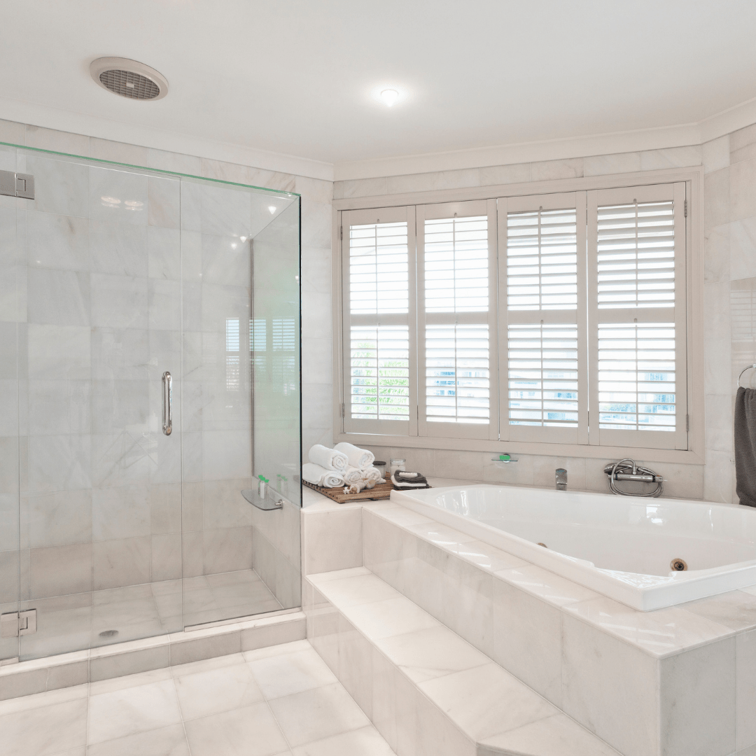 white bathroom with mirror and greenery on the left